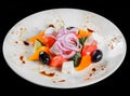 Greek salad in a bowl with fresh vegetables and feta cheese, isolated on black background. Top view Royalty Free Stock Photo