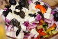 Greek salad, in close-up. Tomatoes, black olives, red onions, cucumber, rosemary, sweet pepper, feta cheese and olive oil. Royalty Free Stock Photo