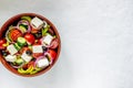 Greek salad on a concrete background. Tomatoes, peppers, olives, cheese, onions. Healthy eating. Diet. Vegetarian food