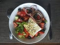 Greek salad in a deep bowl. Tomatoes, cucumbers, peppers, olives, feta cheese, olive oil Royalty Free Stock Photo