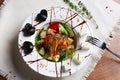 Greek salad in the deep white plate with fork and knife Royalty Free Stock Photo