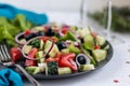 Greek salad. Diced tomatoes, cucumbers, feta cheese, olives. Rings of red onion.