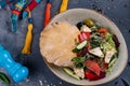 Greek salad with fresh cherry tomatoes, feta cheese, black olives, basil and onion on black stone background, pancake Royalty Free Stock Photo