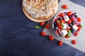 Greek salad with fresh cherry tomatoes, feta cheese, black olives, basil and onion on black wooden background Royalty Free Stock Photo