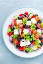 Greek salad of fresh cucumber, tomato, sweet pepper, lettuce, red onion, feta cheese and olives with olive oil Royalty Free Stock Photo