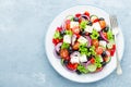 Greek salad of fresh cucumber, tomato, sweet pepper, lettuce, red onion, feta cheese and olives with olive oil Royalty Free Stock Photo