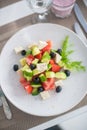 Greek salad of fresh cucumber, tomato, sweet pepper, lettuce, red onion, feta cheese and olives with olive oil Royalty Free Stock Photo