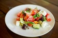 Greek salad of fresh cucumber, tomato, sweet pepper, lettuce, red onion, feta cheese and olives with olive oil. Healthy food, top Royalty Free Stock Photo