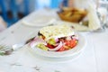 Greek salad of fresh cucumber, tomato, sweet pepper, lettuce, red onion, feta cheese and olives with olive oil topped with feta Royalty Free Stock Photo