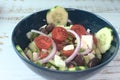 Greek salad of fresh juicy vegetables, feta cheese, herbs and olives in a blue bowl Royalty Free Stock Photo