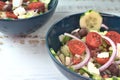 Greek salad of fresh juicy vegetables, feta cheese, herbs and olives in a blue bowl Royalty Free Stock Photo