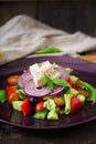 Greek salad with fresh tomato, cucumber, red onion, basil, lettuce, feta cheese, black olives and a Italian herbs Royalty Free Stock Photo