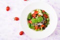 Greek salad with fresh tomato, cucumber, red onion, basil, lettuce, feta cheese, black olives and Italian herbs. Royalty Free Stock Photo