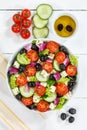 Greek salad with fresh tomatoes olives and feta cheese healthy eating food from above portrait format on a wooden board Royalty Free Stock Photo