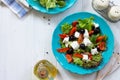 Greek salad with fresh vegetables, feta cheese and black olives in a blue plate on white wooden table. Royalty Free Stock Photo