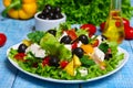Greek salad with fresh vegetables, feta cheese and black olives on a wooden background Royalty Free Stock Photo