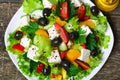 Greek salad with fresh vegetables, feta cheese and black olives on a wooden background Royalty Free Stock Photo