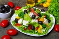 Greek salad with fresh vegetables, feta cheese and black olives on a wooden background Royalty Free Stock Photo