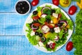 Greek salad with fresh vegetables, feta cheese and black olives on a wooden background Royalty Free Stock Photo