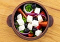 Greek salad with fresh vegetables, feta cheese and black olives on a wooden background. Top view Royalty Free Stock Photo