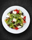 Greek salad with fresh vegetables and feta cheese. Isolated on a black background Royalty Free Stock Photo