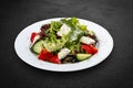 Greek salad with fresh vegetables and feta cheese. Isolated on a black background Royalty Free Stock Photo