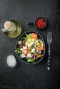 Greek salad with fresh vegetables, feta cheese and olives, on black background, top view flat lay Royalty Free Stock Photo