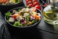 Greek salad with fresh vegetables, feta cheese and olives, on black wooden table background Royalty Free Stock Photo