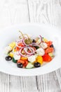 Greek salad with fresh vegetables, olives and feta cheese on wooden background close up. Top view. Royalty Free Stock Photo