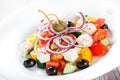 Greek salad with fresh vegetables, olives and feta cheese on wooden background close up. Royalty Free Stock Photo