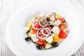 Greek salad with fresh vegetables, olives and feta cheese on wooden background Royalty Free Stock Photo