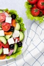 Greek salad or horiatiki salad made with pieces of tomatoes, cucumbers, onion, feta cheese, bell pepper slices, olives and dressed Royalty Free Stock Photo