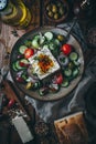 Greek salad ingredients with olive oil dressing, top down view on rustic wooden table Royalty Free Stock Photo