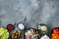 Greek salad main ingredients: fresh olives mix, feta cheese, tomatoes, pepper, on gray background, top view flat lay  with copy Royalty Free Stock Photo