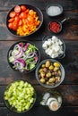 Greek salad main ingredients: fresh olives mix, feta cheese, tomatoes, pepper, on old dark  wooden table background, top view flat Royalty Free Stock Photo