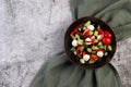 Greek salad with olives, bell peppers, tomatoes, cucumbers and mozzarella cheese in a bowl on a dark background Royalty Free Stock Photo