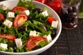 Greek Salad with Olives Tomatos and Feta Cheese on a Rustic Wood Table Royalty Free Stock Photo