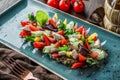 Greek salad of organic vegetables with tomatoes, cucumbers, olives, feta cheese in plate over brown wooden background Royalty Free Stock Photo