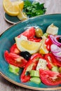 Greek salad of organic vegetables with tomatoes, cucumbers, red onion, olives, feta cheese and glass of wine Royalty Free Stock Photo