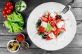 Greek salad of organic vegetables with tomatoes, cucumbers, red onion, olives, feta cheese and sweet pepper on wooden background Royalty Free Stock Photo