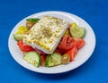 Greek salad plate with original feta cheese, olives, green pepper slices, tomatoes, onions and cucumber slices.