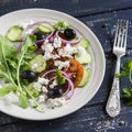 Greek salad - salad with tomatoes, cucumbers, olives and feta cheese on a white plate Royalty Free Stock Photo