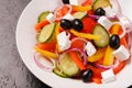 Greek salad with tomatoes, cucumbers, olives, pepper and soft feta cheese in a  plate on a dark Royalty Free Stock Photo