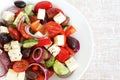 Greek Salad of tomatoes, cucumbers, sweet peppers, feta cheese, dark olives, purple onions Royalty Free Stock Photo