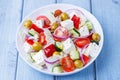 Greek salad. Traditional Greek dish. Healthy vegetarian food. Fresh vegetables and feta cheese in a white plate. Royalty Free Stock Photo