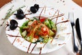 Greek salad in the white deep plate with the fork and knife Royalty Free Stock Photo