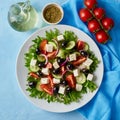 Greek salad on white plate on bright blue table, top view Royalty Free Stock Photo