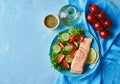 Greek salad on white plate on bright blue table, top view, copy space Royalty Free Stock Photo