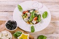 Greek salad in a white plate. Mediterranean vegetable salad with fresh basil, olives, feta cheese, olive oil and spices. Close-up Royalty Free Stock Photo