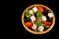Greek Salad, in wooden bowl Close up isolated on black background,top view, copy space Royalty Free Stock Photo